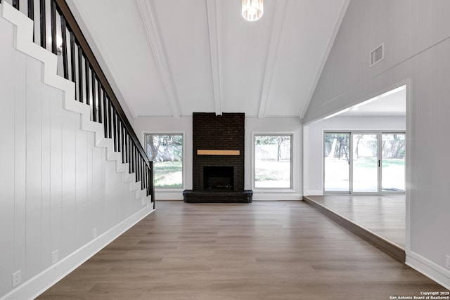 5411 Lancashire, San Antonio, TX 78230 - unfurnished living room with wood finished floors, a brick fireplace, beamed ceiling, high vaulted ceiling, and baseboards