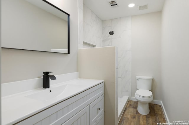 11375 Olney Spgs, San Antonio, TX 78245 - bathroom with toilet, vanity, wood finished floors, tiled shower, and recessed lighting