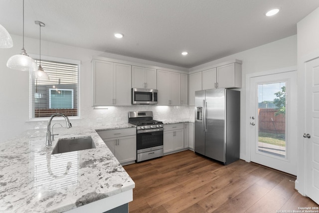 9607 Stillwater Pass, San Antonio, TX 78254 - kitchen featuring stainless steel appliances, a sink, light stone counters, backsplash, and dark wood-style floors