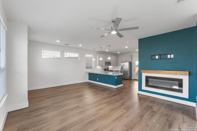9607 Stillwater Pass, San Antonio, TX 78254 - unfurnished living room featuring ceiling fan, wood finished floors, recessed lighting, baseboards, and a sink