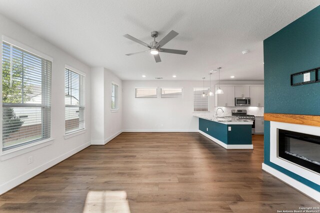 9607 Stillwater Pass, San Antonio, TX 78254 - unfurnished living room featuring a sink, a ceiling fan, baseboards, dark wood finished floors, and recessed lighting