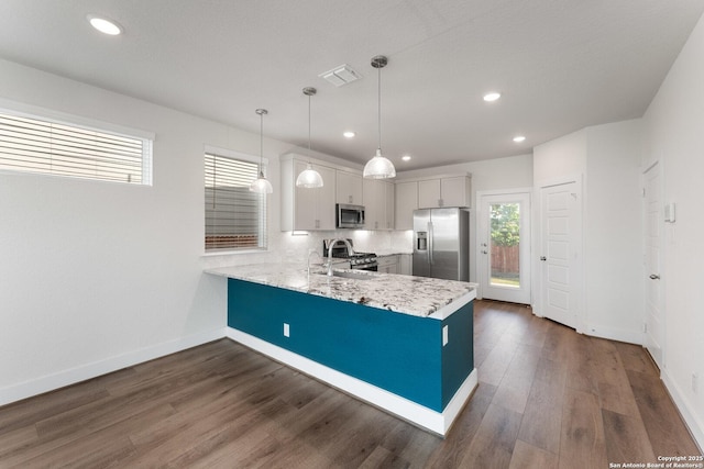 9607 Stillwater Pass, San Antonio, TX 78254 - kitchen with stainless steel appliances, a peninsula, baseboards, dark wood-style flooring, and recessed lighting