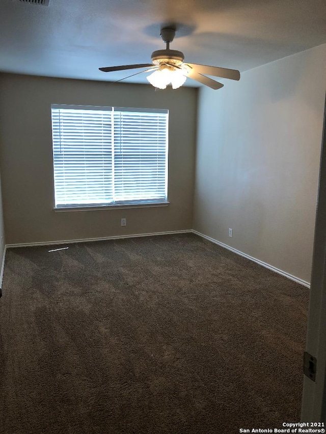 5514 Justin, San Antonio, TX 78240 - empty room featuring dark colored carpet, baseboards, and a ceiling fan