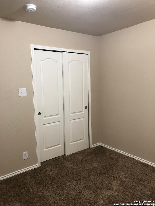 5514 Justin, San Antonio, TX 78240 - unfurnished bedroom with dark carpet, a closet, and baseboards