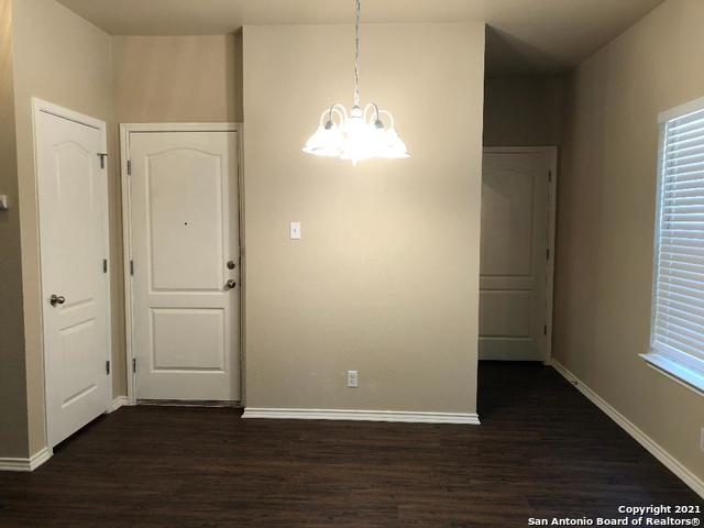 5514 Justin, San Antonio, TX 78240 - unfurnished dining area with dark wood finished floors, a chandelier, and baseboards