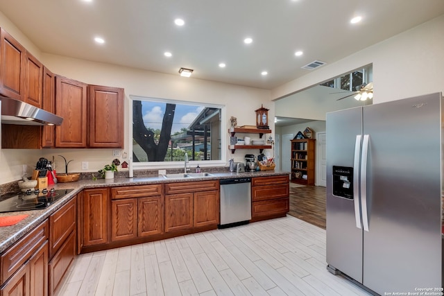 246 Felisa St, San Antonio, TX 78210 - kitchen featuring appliances with stainless steel finishes, a sink, under cabinet range hood, brown cabinets, and dark countertops
