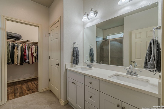 124 Mary Max Cir, San Marcos, TX 78666 - full bath featuring double vanity, a stall shower, tile patterned flooring, and a walk in closet