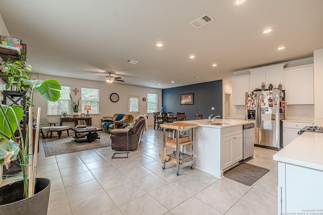 124 Mary Max Cir, San Marcos, TX 78666 - kitchen with stainless steel appliances, open floor plan, a sink, light countertops, and ceiling fan