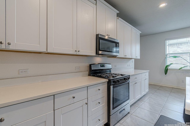 124 Mary Max Cir, San Marcos, TX 78666 - kitchen with stainless steel appliances, white cabinets, light countertops, light tile patterned floors, and baseboards