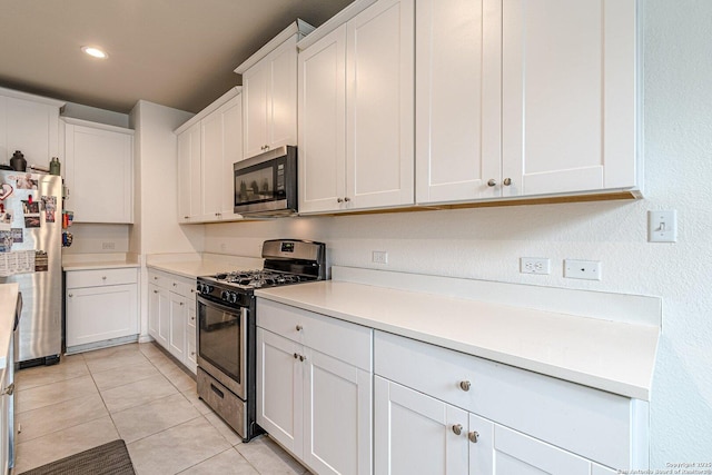 124 Mary Max Cir, San Marcos, TX 78666 - kitchen featuring stainless steel appliances, light tile patterned flooring, white cabinets, light countertops, and recessed lighting