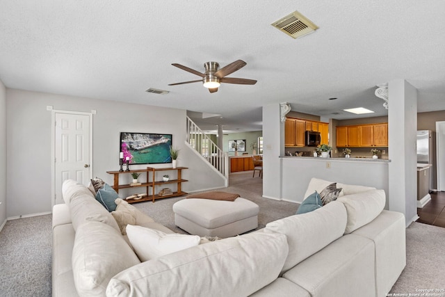 18718 Legend Oaks, San Antonio, TX 78259 - carpeted living area with baseboards, a ceiling fan, stairs, and a textured ceiling