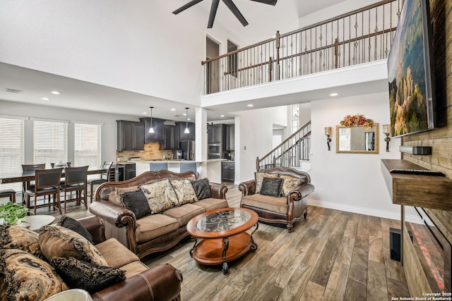 14042 Gemma, San Antonio, TX 78253 - living room with wood finished floors, a ceiling fan, a towering ceiling, stairway, and baseboards