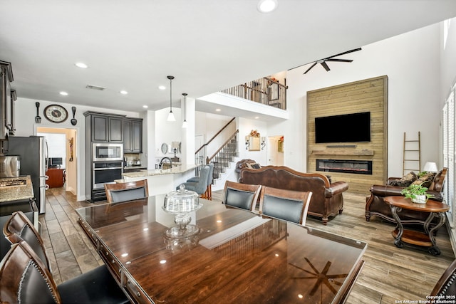 14042 Gemma, San Antonio, TX 78253 - dining area with wood finished floors, a glass covered fireplace, recessed lighting, and stairs