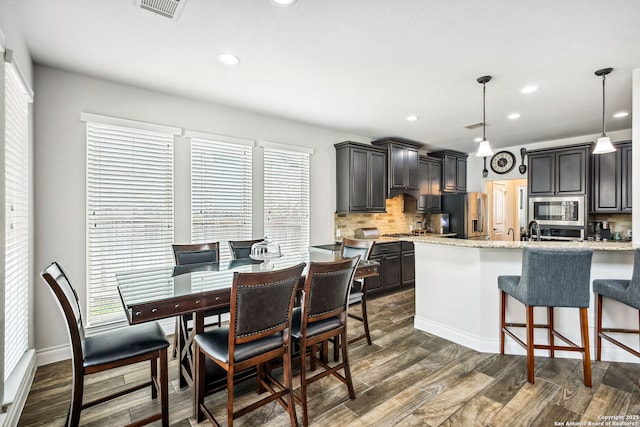 14042 Gemma, San Antonio, TX 78253 - kitchen featuring appliances with stainless steel finishes, backsplash, dark wood finished floors, a breakfast bar area, and recessed lighting