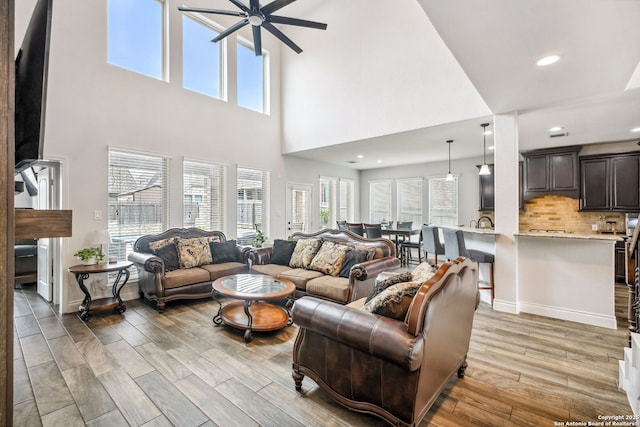 14042 Gemma, San Antonio, TX 78253 - living room with a ceiling fan, plenty of natural light, light wood-style flooring, a towering ceiling, and baseboards