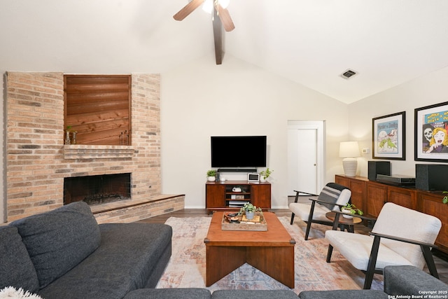 5535 Timber Cyn, San Antonio, TX 78250 - living area featuring a ceiling fan, beamed ceiling, wood finished floors, a fireplace, and high vaulted ceiling