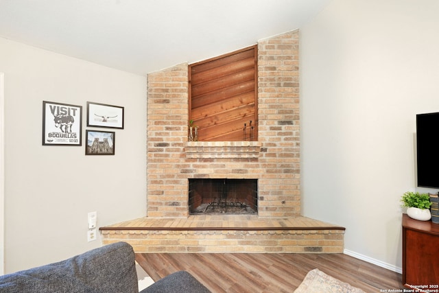 5535 Timber Cyn, San Antonio, TX 78250 - living area featuring wood finished floors, a fireplace, baseboards, and vaulted ceiling