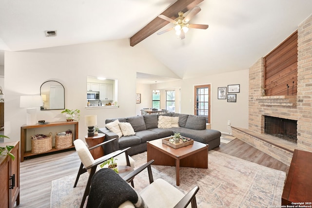 5535 Timber Cyn, San Antonio, TX 78250 - living room with light wood finished floors, a ceiling fan, and a brick fireplace