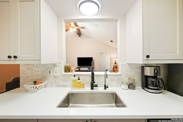 5535 Timber Cyn, San Antonio, TX 78250 - kitchen with a sink, decorative backsplash, light countertops, vaulted ceiling, and white cabinetry