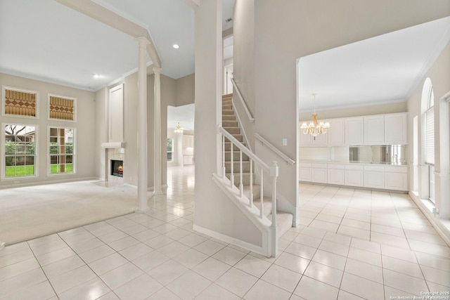 15618 Dawn Crst, San Antonio, TX 78248 - unfurnished living room with light tile patterned flooring, a lit fireplace, stairs, ornamental molding, and a chandelier
