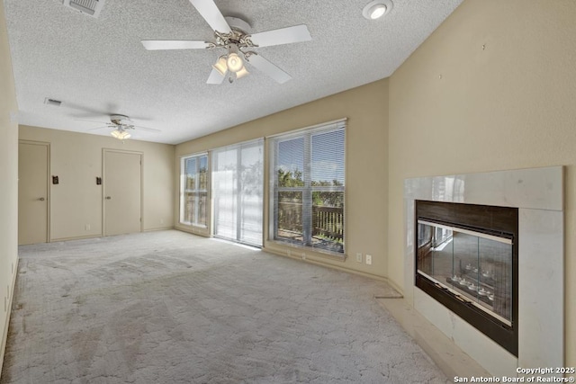 642 Lakebreeze, Canyon Lake, TX 78133 - unfurnished living room featuring a textured ceiling, light colored carpet, ceiling fan, and a fireplace