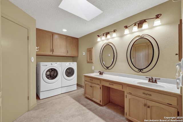 642 Lakebreeze, Canyon Lake, TX 78133 - bathroom with washing machine and clothes dryer, a skylight, a textured ceiling, and double vanity