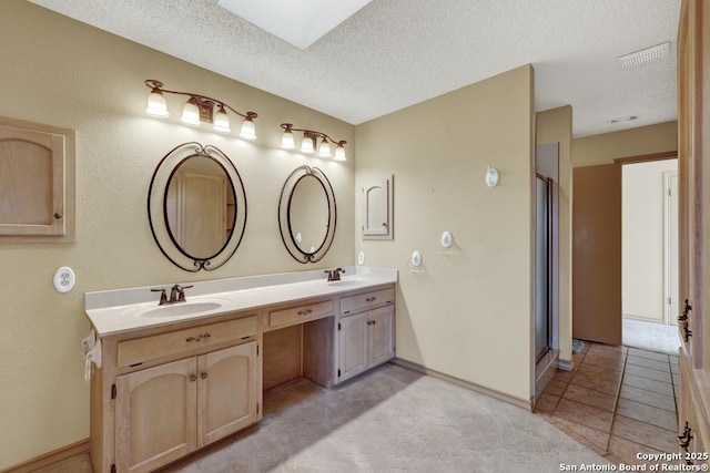 642 Lakebreeze, Canyon Lake, TX 78133 - full bathroom with double vanity, a textured ceiling, a skylight, and an enclosed shower