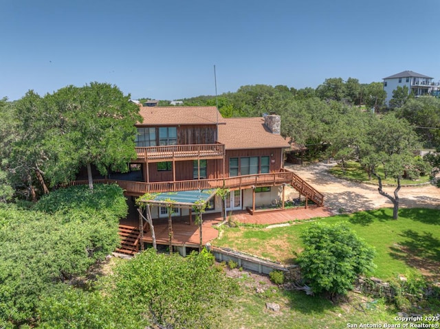 642 Lakebreeze, Canyon Lake, TX 78133 - back of property featuring stairs, a chimney, a deck, and a yard