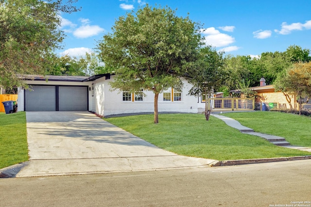 207 Northaven, San Antonio, TX 78229 - view of front of house with a front lawn, a garage, driveway, and brick siding