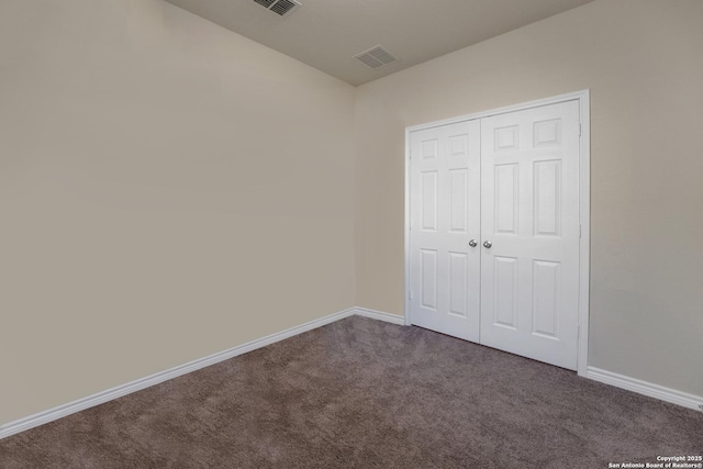 1919 Overlook Knl, San Antonio, TX 78245 - unfurnished bedroom with dark carpet, baseboards, and a closet