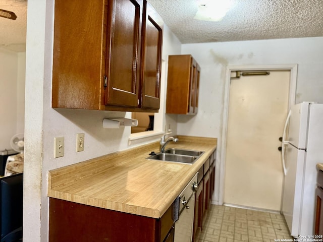 9010 Bowline, San Antonio, TX 78242 - kitchen with a sink, freestanding refrigerator, a textured ceiling, and light countertops