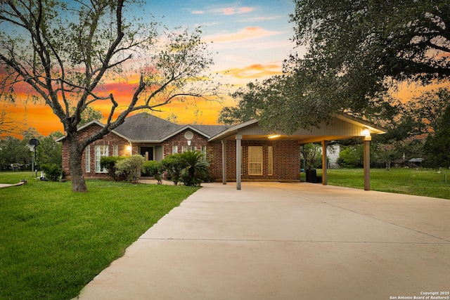 13040 Tomlynn, Atascosa, TX 78002 - view of front of house with a front yard, driveway, brick siding, and a carport