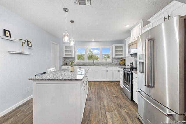 13040 Tomlynn, Atascosa, TX 78002 - kitchen featuring appliances with stainless steel finishes, tasteful backsplash, dark wood-style flooring, white cabinets, and glass insert cabinets