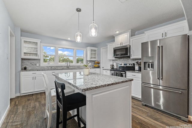 13040 Tomlynn, Atascosa, TX 78002 - kitchen with appliances with stainless steel finishes, glass insert cabinets, decorative backsplash, a center island, and recessed lighting