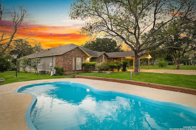 13040 Tomlynn, Atascosa, TX 78002 - pool at dusk featuring a yard and an outdoor pool