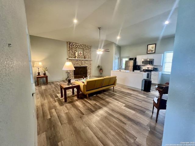 415 Fort Clark Rd Unit 21, Brackettville, TX 78832 - living area featuring a ceiling fan, wood finished floors, vaulted ceiling, and a fireplace