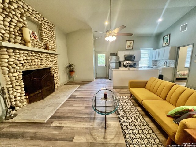 415 Fort Clark Rd Unit 21, Brackettville, TX 78832 - living area with ceiling fan, light wood-type flooring, and a fireplace