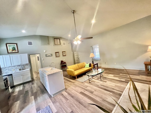 415 Fort Clark Rd Unit 21, Brackettville, TX 78832 - living room featuring a ceiling fan, light wood finished floors, high vaulted ceiling, and baseboards