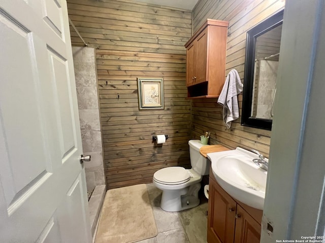 415 Fort Clark Rd Unit 21, Brackettville, TX 78832 - bathroom with wooden walls, toilet, vanity, a shower, and tile patterned flooring