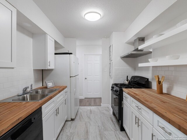 13306 Chesterton, San Antonio, TX 78217 - kitchen featuring wooden counters, black appliances, wall chimney range hood, open shelves, and white cabinets