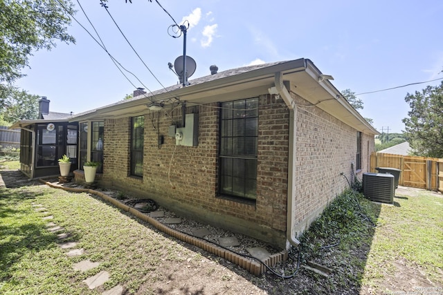 3105 Pecan Valley Dr, Temple, TX 76502 - view of side of home with brick siding, a chimney, a sunroom, and cooling unit