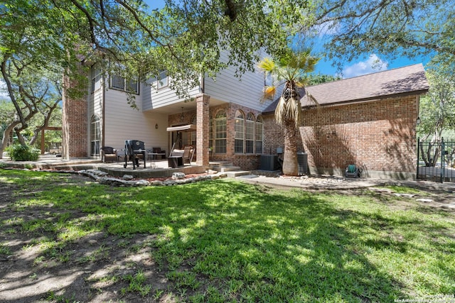 18203 Newcliff, San Antonio, TX 78259 - rear view of property featuring brick siding, a patio area, a yard, and central AC