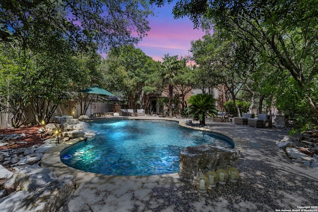 18203 Newcliff, San Antonio, TX 78259 - pool at dusk featuring a patio, an outdoor hangout area, and a fenced backyard