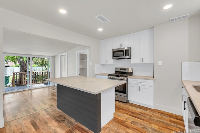 339 Thorain Blvd, San Antonio, TX 78212 - kitchen featuring stainless steel appliances, light stone countertops, light wood-style floors, white cabinetry, and ornamental molding