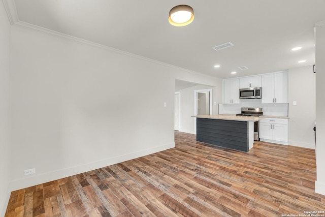 339 Thorain Blvd, San Antonio, TX 78212 - kitchen featuring stainless steel appliances, light wood-type flooring, white cabinetry, ornamental molding, and recessed lighting