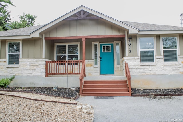 2073 Robin Hood, Canyon Lake, TX 78133 - bungalow featuring stone siding, roof with shingles, a porch, and board and batten siding