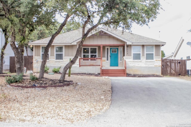 2073 Robin Hood, Canyon Lake, TX 78133 - view of front of home featuring a porch, stone siding, board and batten siding, and asphalt driveway