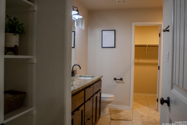 2073 Robin Hood, Canyon Lake, TX 78133 - bathroom with double vanity, toilet, tile patterned flooring, a walk in closet, and baseboards