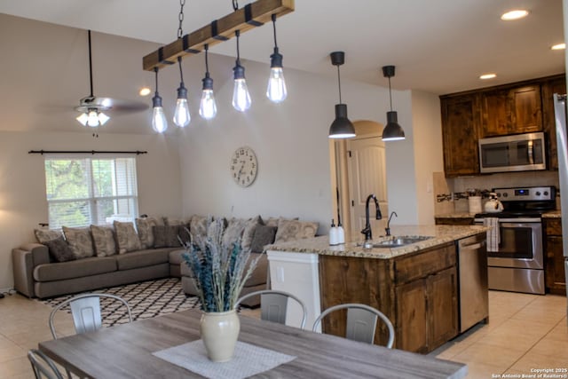 2073 Robin Hood, Canyon Lake, TX 78133 - kitchen with stainless steel appliances, a sink, light tile patterned flooring, light stone counters, and pendant lighting