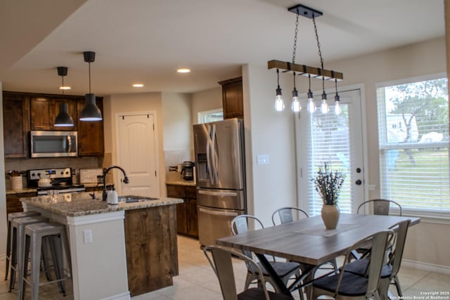 2073 Robin Hood, Canyon Lake, TX 78133 - kitchen with appliances with stainless steel finishes, a sink, dark brown cabinetry, a kitchen island with sink, and recessed lighting